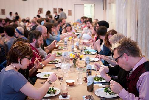 Guests hear presentations while enjoying local food.