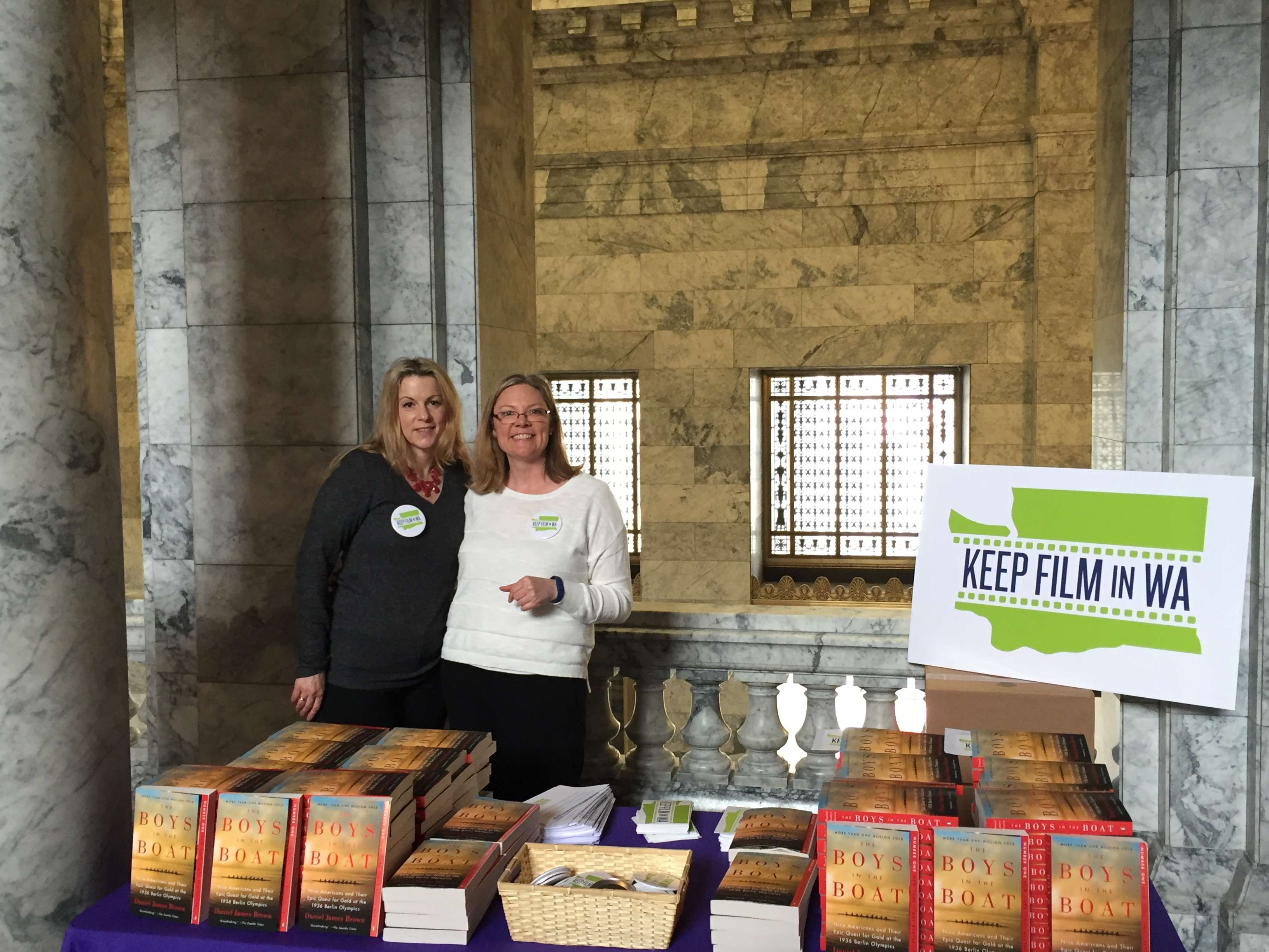Amy Lillard and Krys Karns from WF distribute "The Boys in the Boat" books to legislators at the Capitol on Monday.